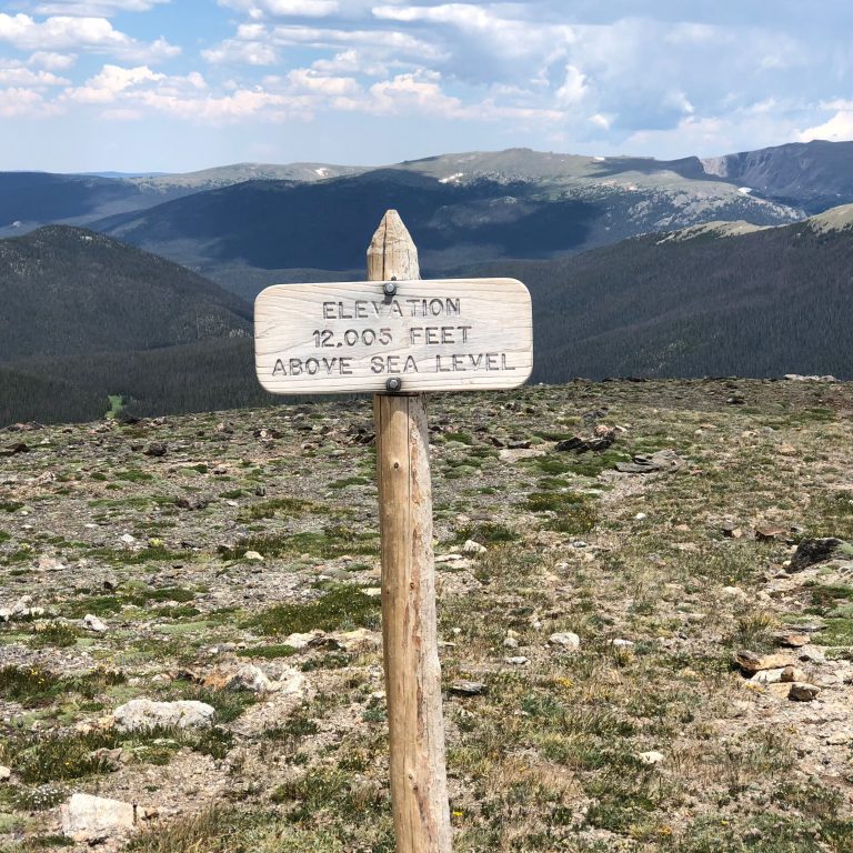 View from 12,005 feet above sea level in Rocky Mountain National Park, showcasing high altitude terrain and thin mountain air.
